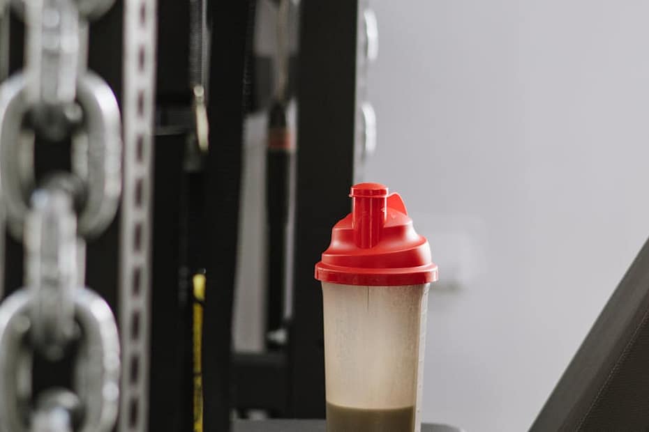 A protein shake bottle on gym equipment symbolizing fitness and health.