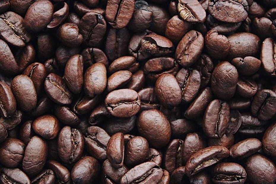 A detailed view of aromatic roasted Arabica coffee beans, highlighting texture and brown color.