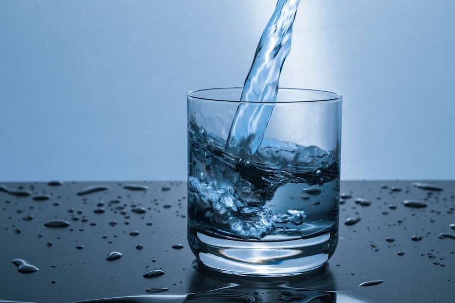 High-quality image of water being poured into a glass, illustrating hydration and purity.