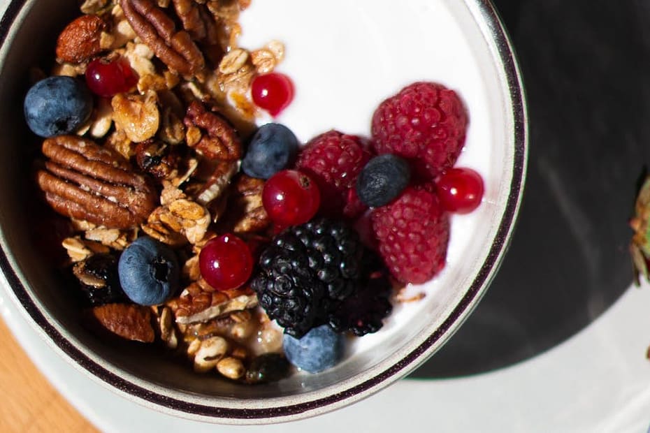Delicious breakfast bowl with yogurt, fresh berries, and granola on table.