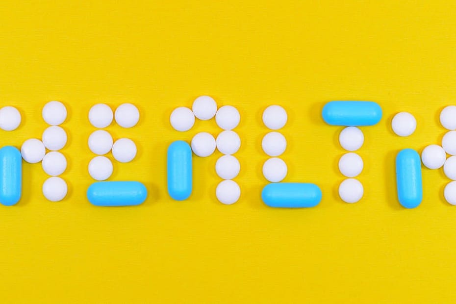 Pills spelling 'health' on a vibrant yellow background, symbolizing wellness.