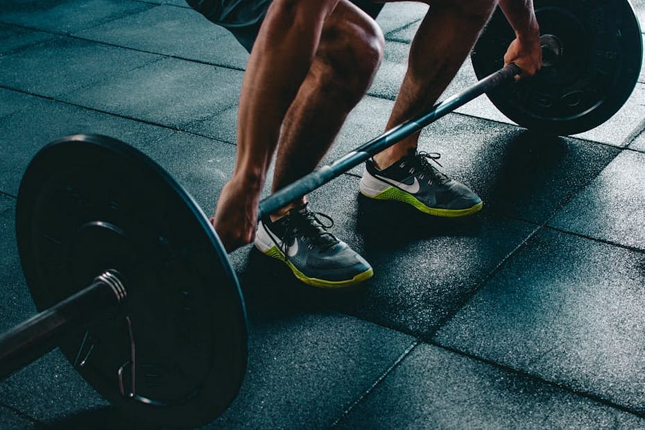 Man performing a deadlift exercise in a gym, demonstrating strength and fitness.