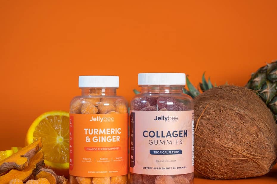 Colorful tropical gummies with fresh fruits including coconut, pineapple, and orange.