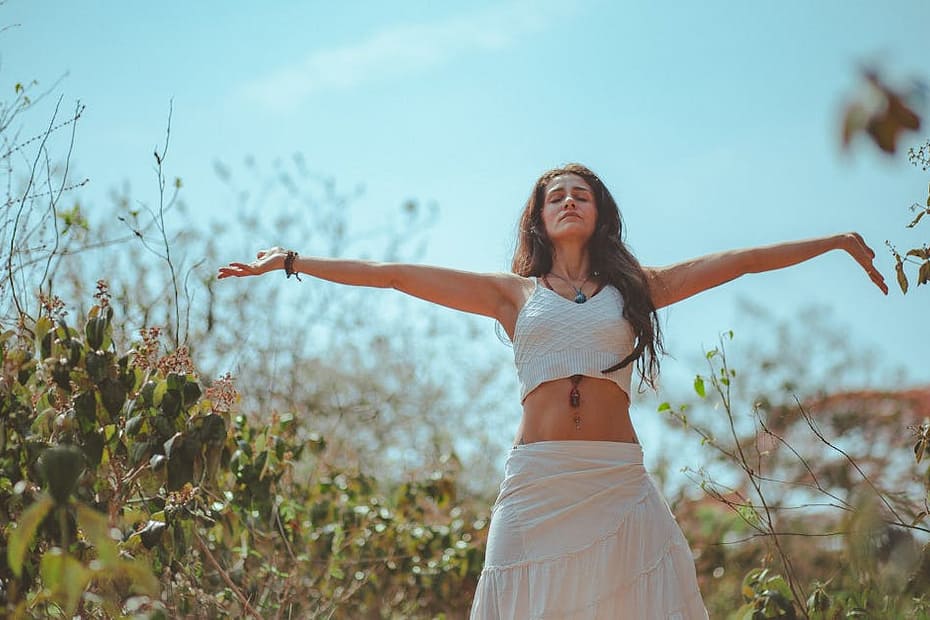 Peaceful scene of a woman meditating outdoors in a sunny summer setting, embodying wellness and tranquility.