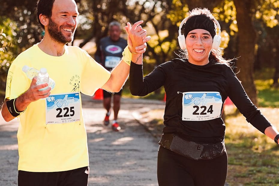 Happy runners celebrate finishing a race outdoors, showcasing team spirit and fitness.