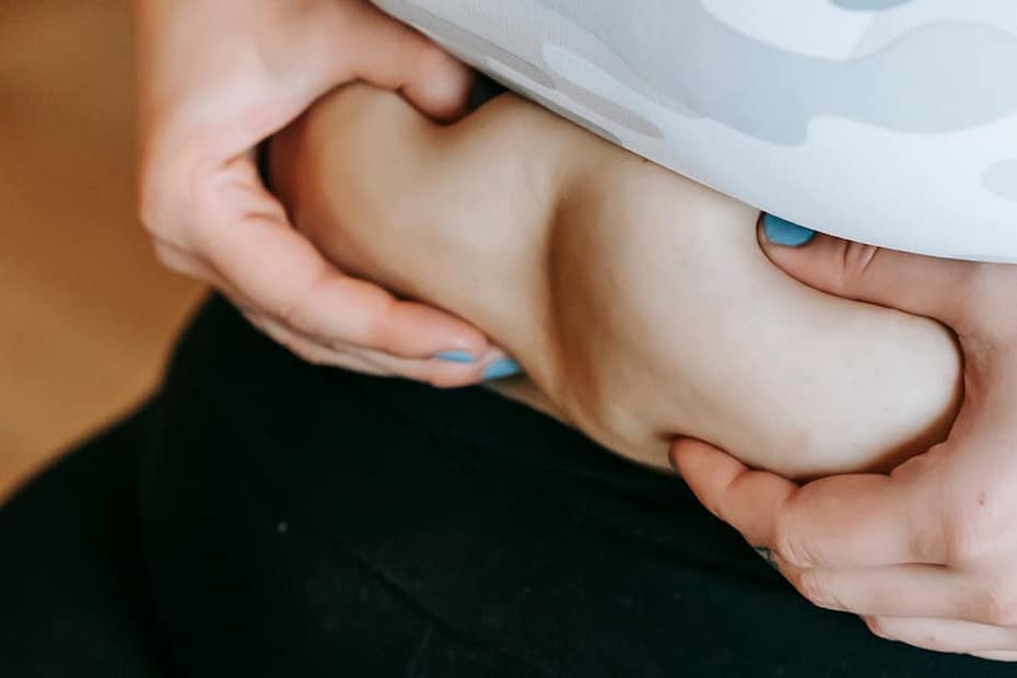 Close-up of a woman embracing her body during a workout in the gym.
