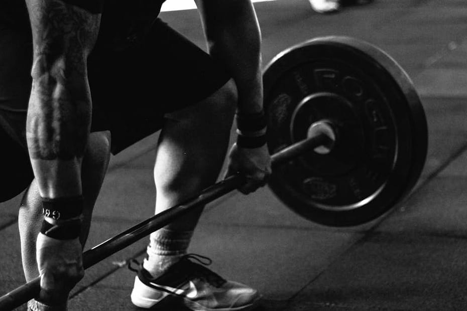 A powerful black and white image of a man deadlifting in a gym, showcasing strength and fitness.