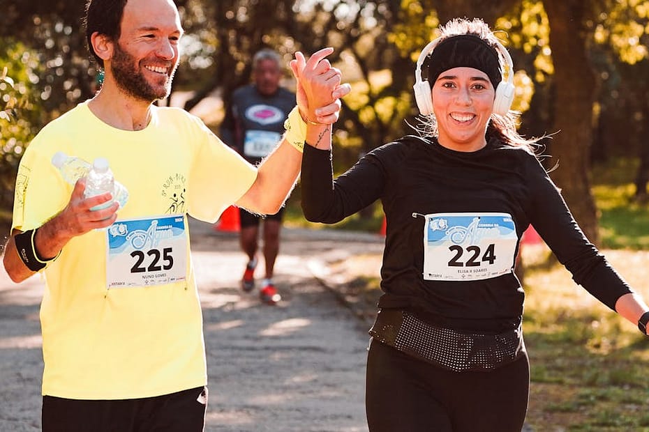 Happy runners celebrate finishing a race outdoors, showcasing team spirit and fitness.